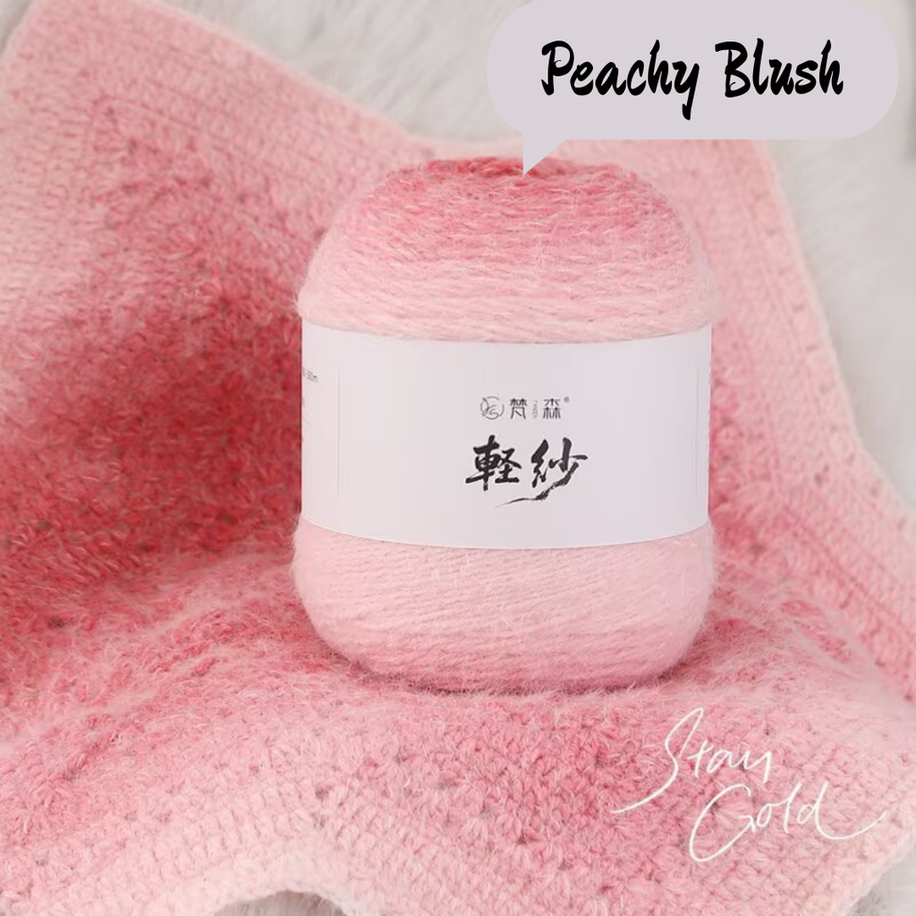 Ball of yarn labeled 'Peachy Blush' on a pink textured background