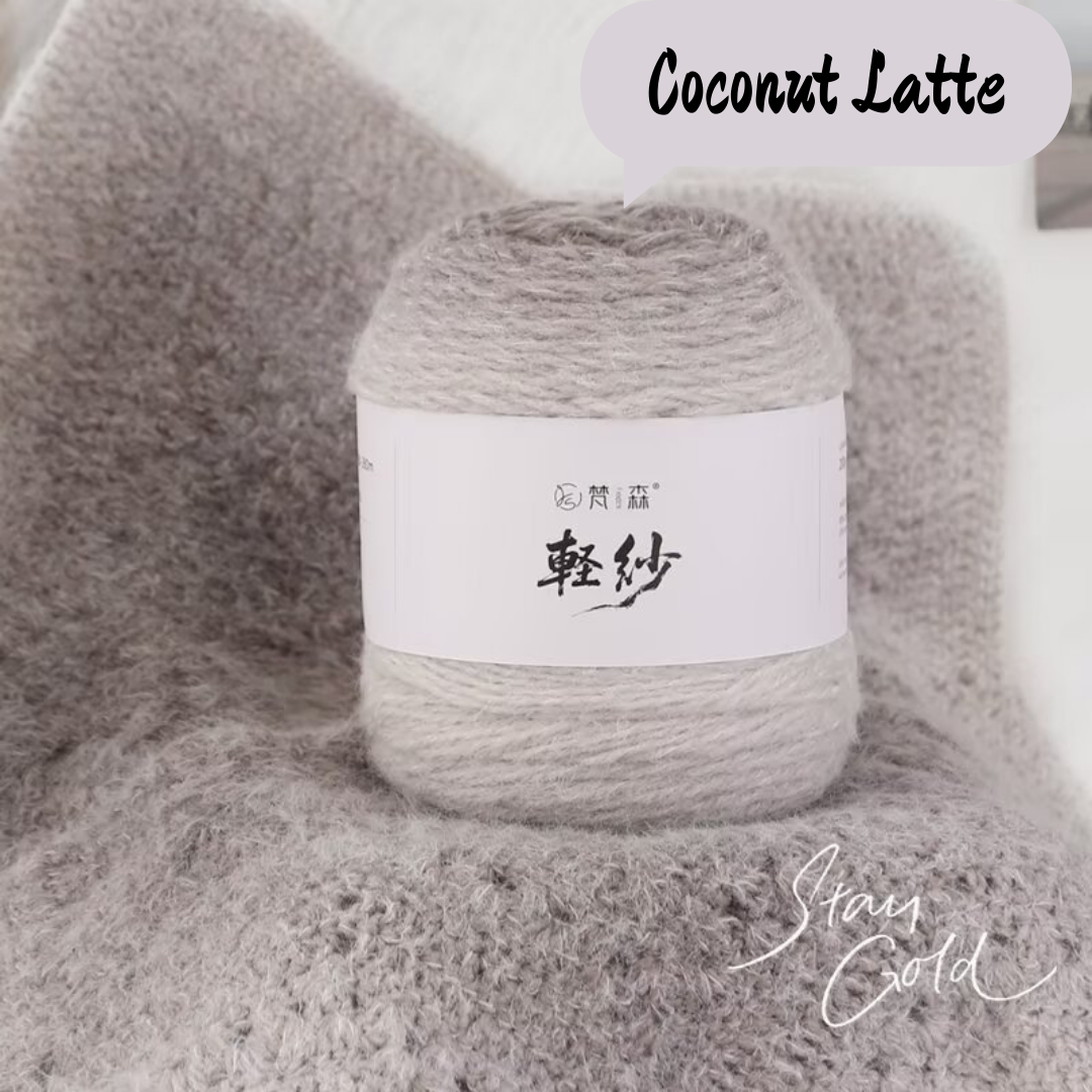 Ball of yarn labeled 'Coconut Latte' on a textured gray background