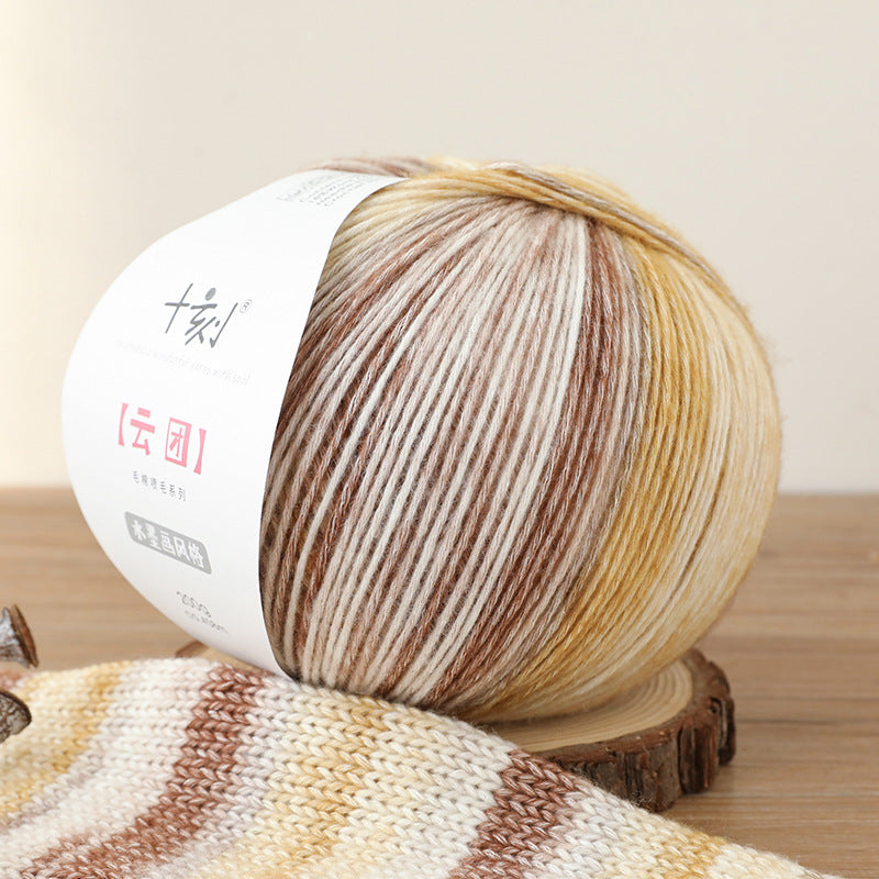 Ball of yarn with a gradient pattern on a wooden surface