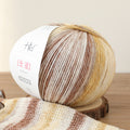 Ball of yarn with a gradient pattern on a wooden surface