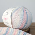 Multicolored yarn ball with a label on a wooden surface