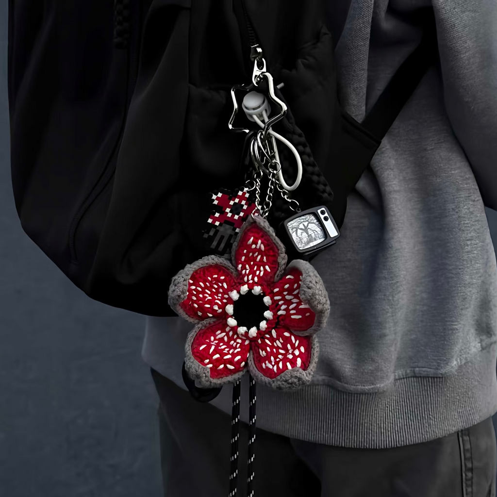 Person wearing a black backpack with a Hand-crocheted Demogorgon plush toy