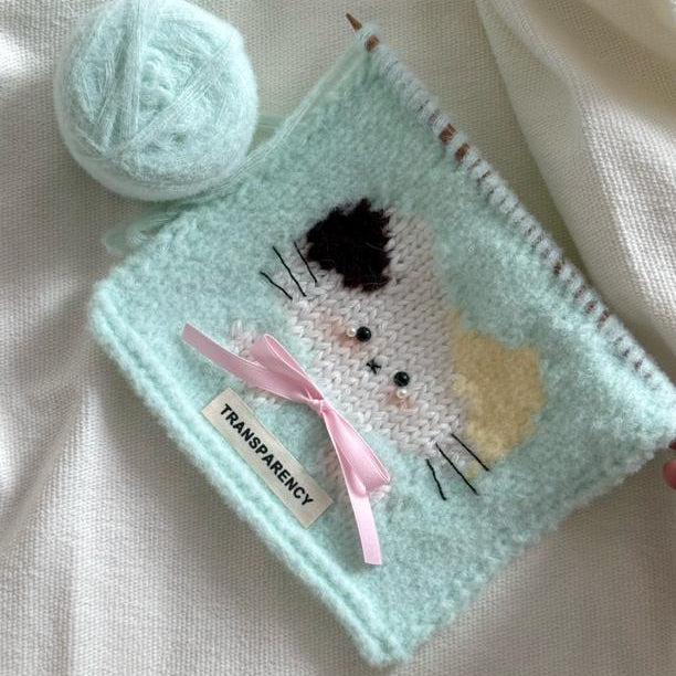 Handmade crochet cat pattern scarf kit with pastel yarn, knitting needles and cute kitten design, beginner-friendly crochet kit for cosy winter accessories