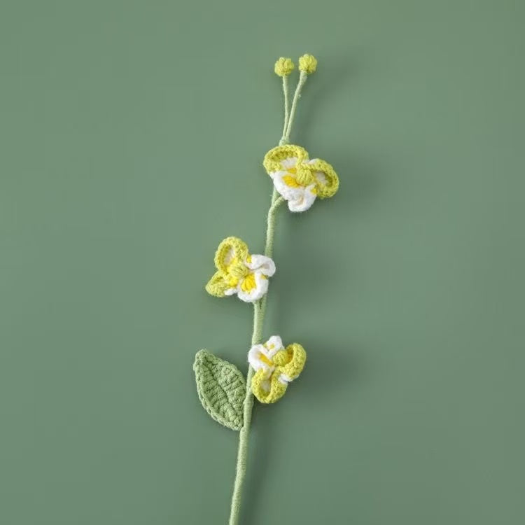 Handcrafted crochet Phalaenopsis orchid flower stem in green and white, perfect for elegant home décor or a thoughtful handmade gift for her – UK eco-friendly floral craft.