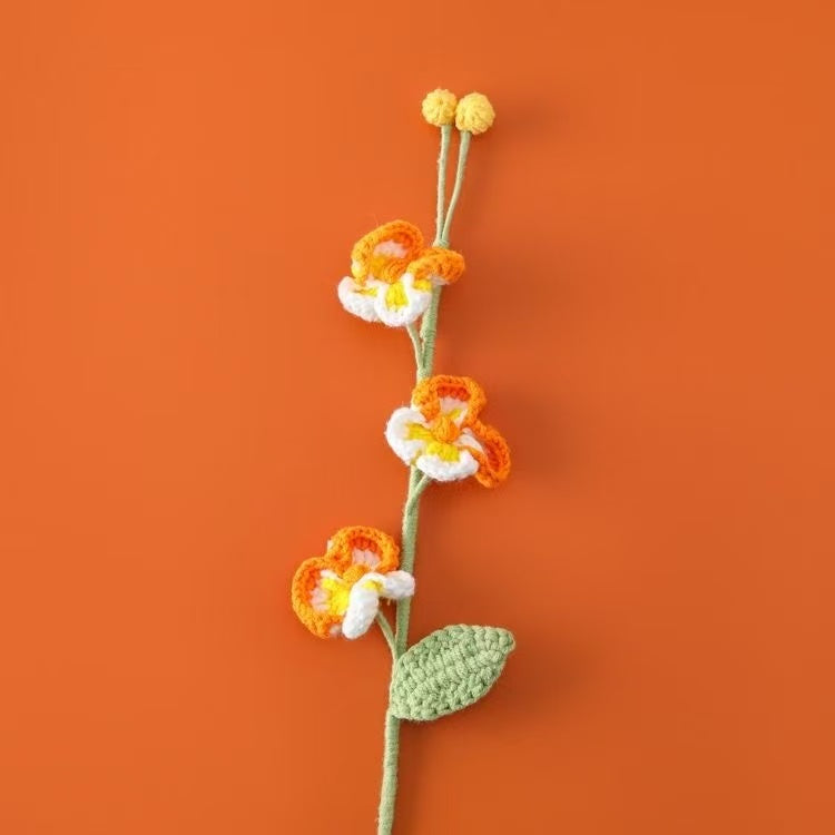Handcrafted crochet Phalaenopsis orchid flower stem in orange and white, perfect for elegant home décor or a thoughtful handmade gift for her – UK eco-friendly floral craft.