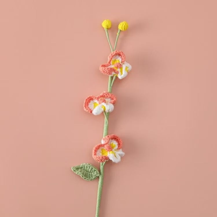 Handcrafted crochet Phalaenopsis orchid flower stem in soft peach pink and white, perfect for elegant home décor or a thoughtful handmade gift for her – UK eco-friendly floral craft.