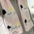 Pair of pink scarf with cat designs and a bow on a gray background