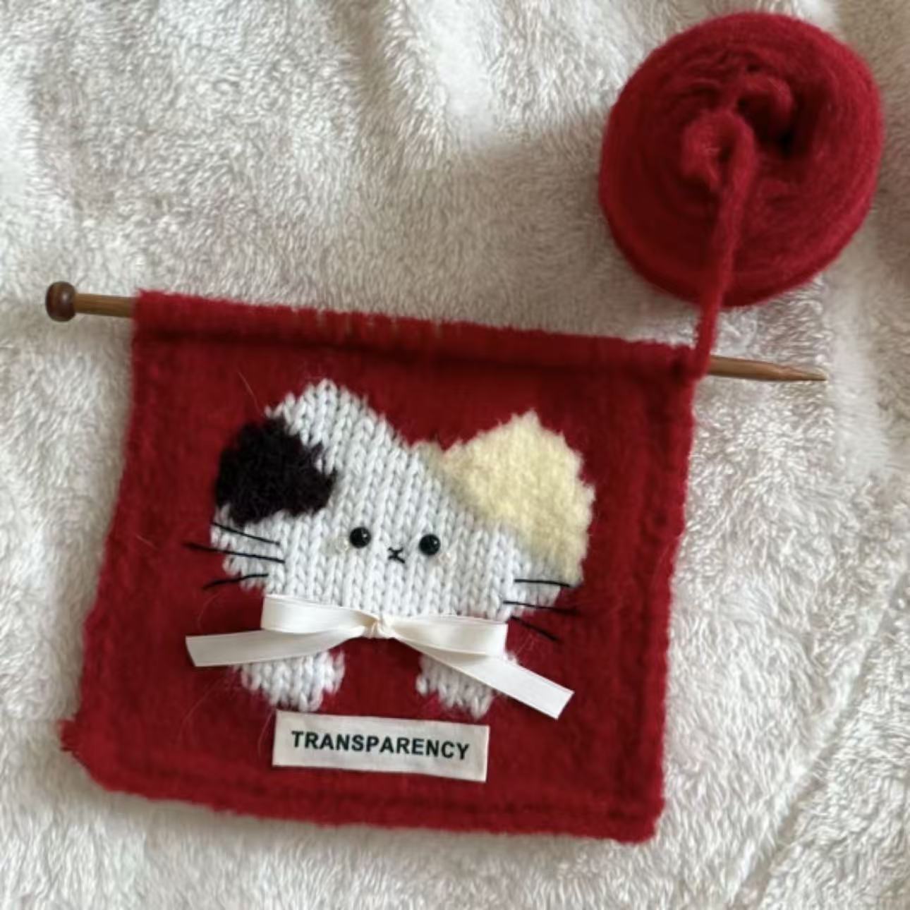 Handmade crochet cat pattern scarf kit with red yarn, knitting needles and cute kitten design, beginner-friendly crochet kit for cosy winter accessories