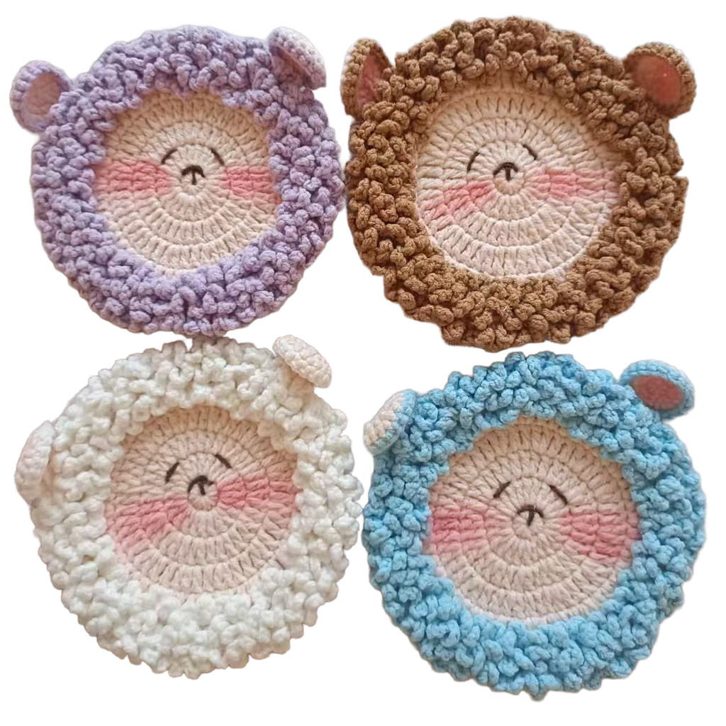 Four round, crocheted coasters with animal sheep faces in purple, brown, white, and blue on a white background.