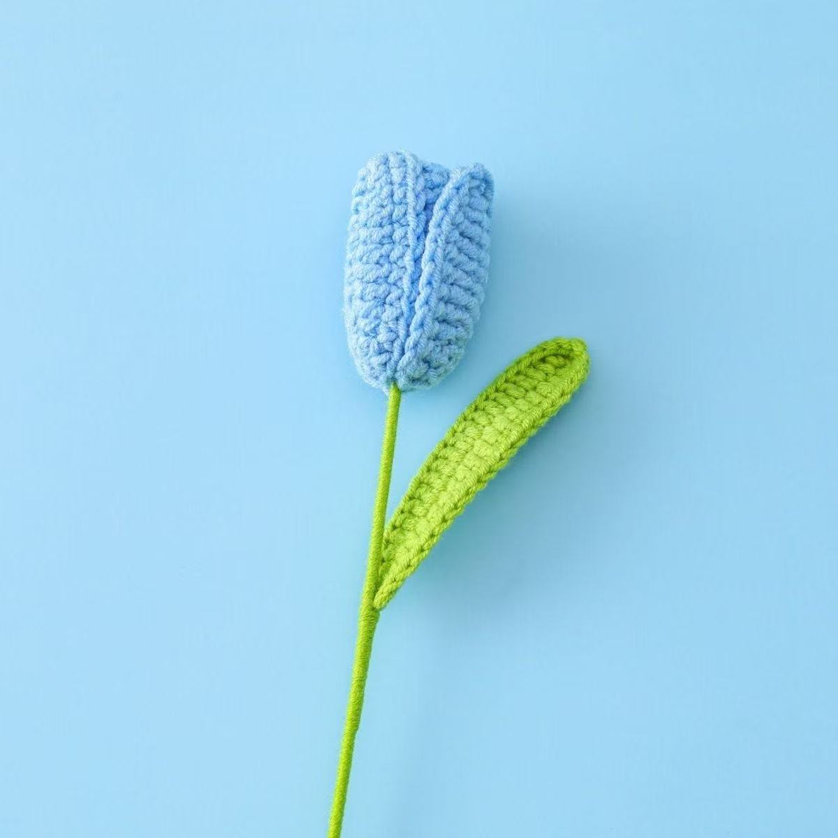 Handmade crochet tulip flower with  blue knitted bud and green stem, decorative artificial crochet flower for home décor or gift