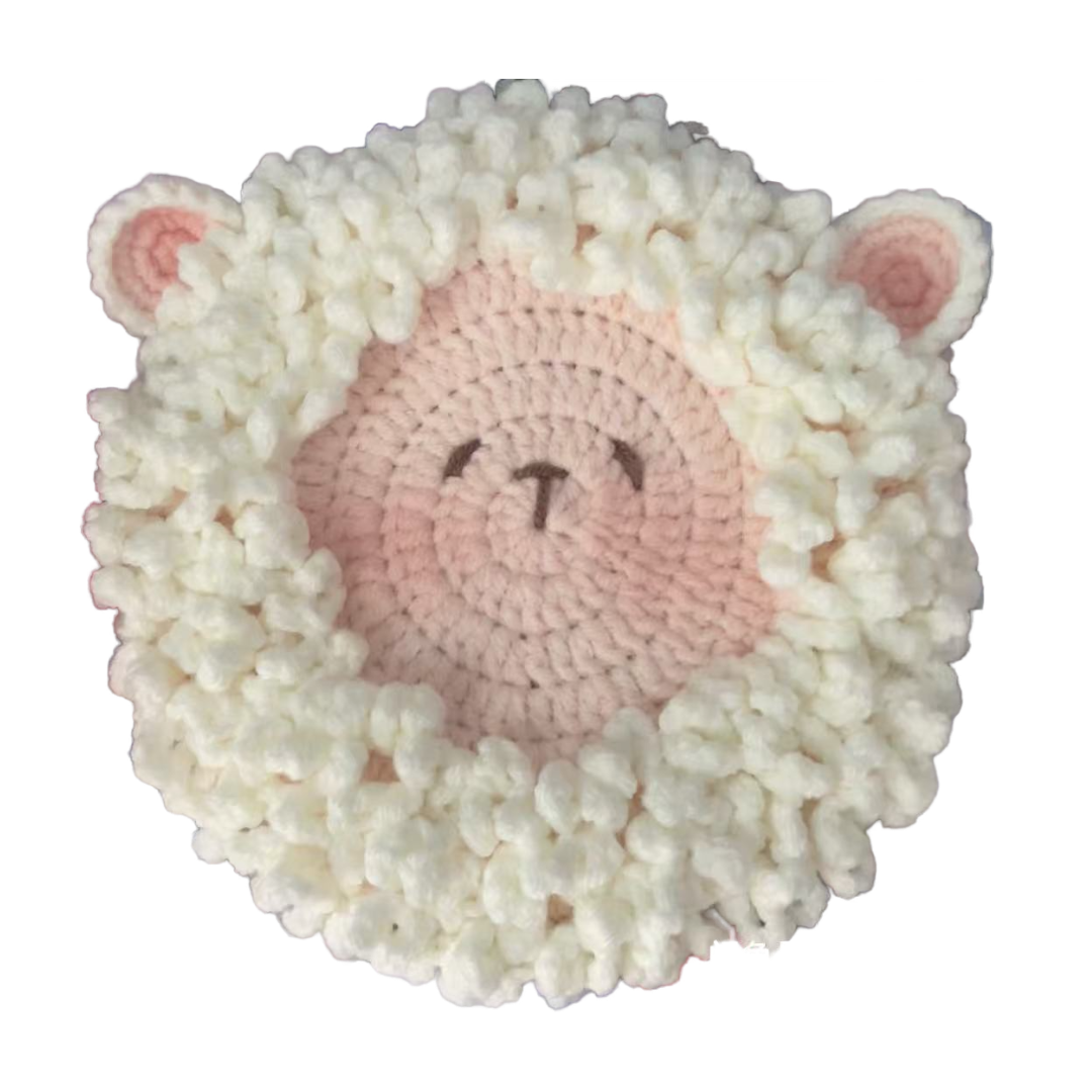 Crocheted sheep toy with white wool and pink face on a white background