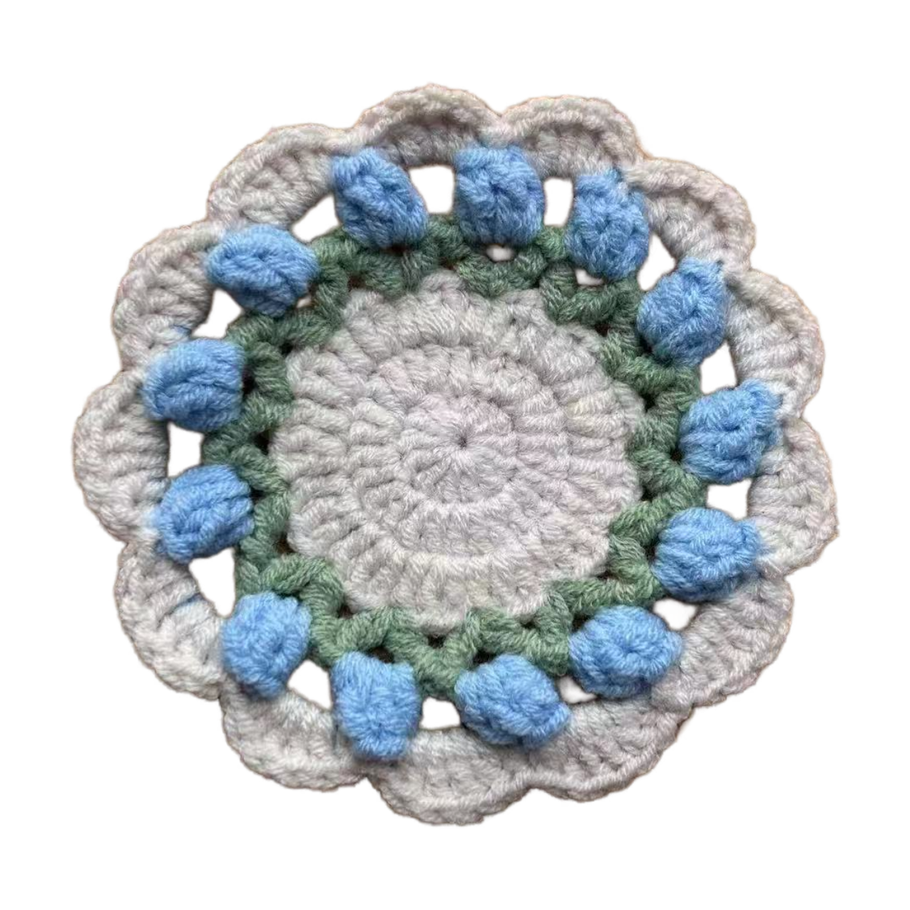 Crocheted coaster with blue and green accents on a white background
