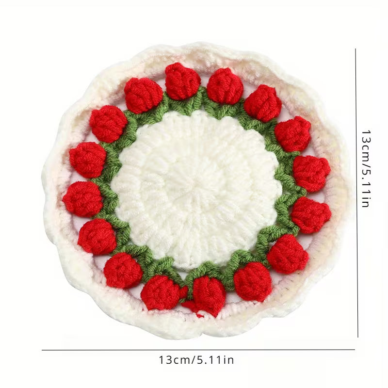 Round crocheted mat with red floral pattern on a white background