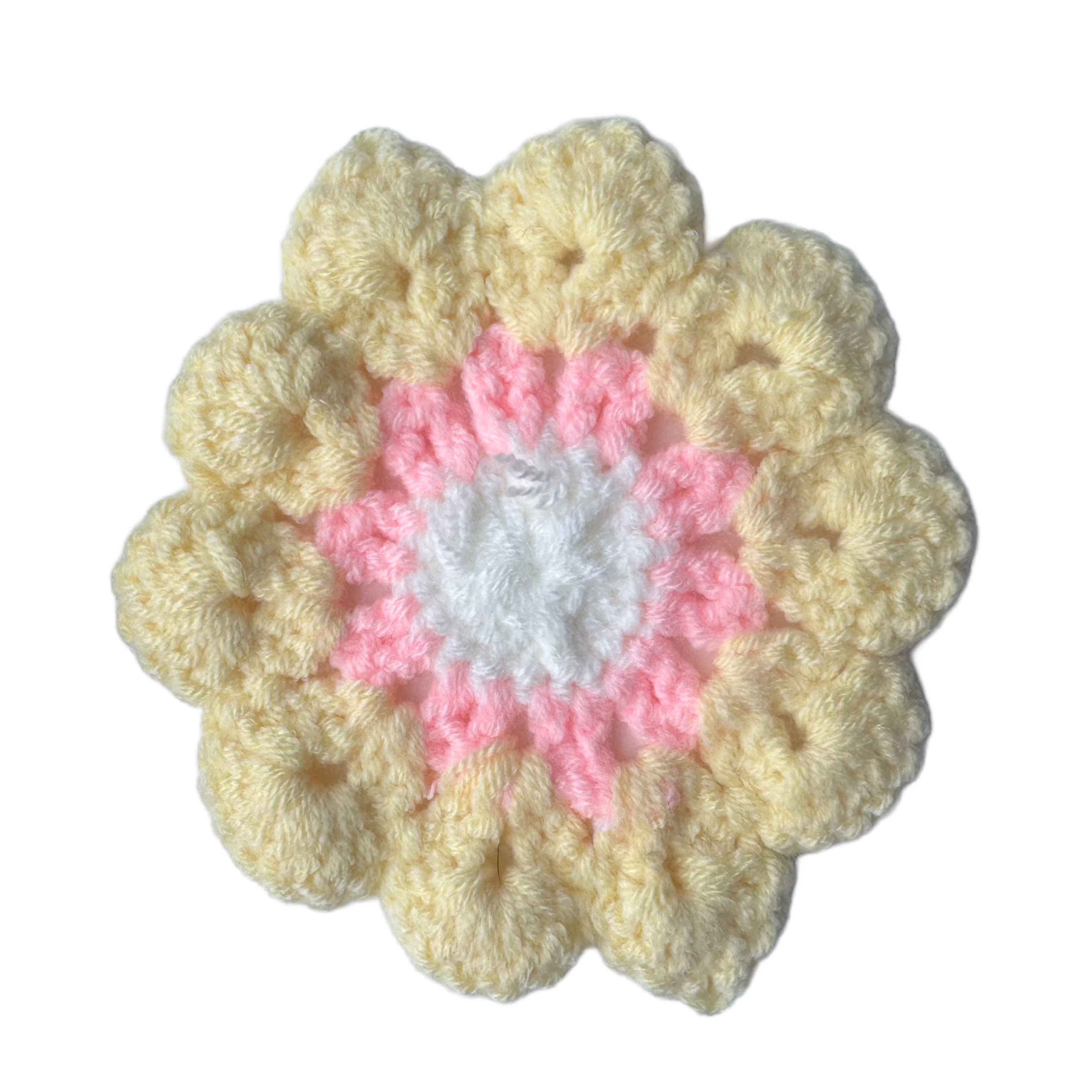 Crocheted flower with beige petals and a pink center on a white background