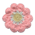 Pink crocheted flower with a yellow center on a white background