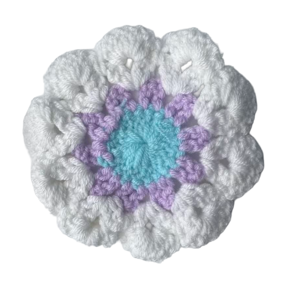 Crocheted flower with white outer petals, purple middle, and blue center on a white background