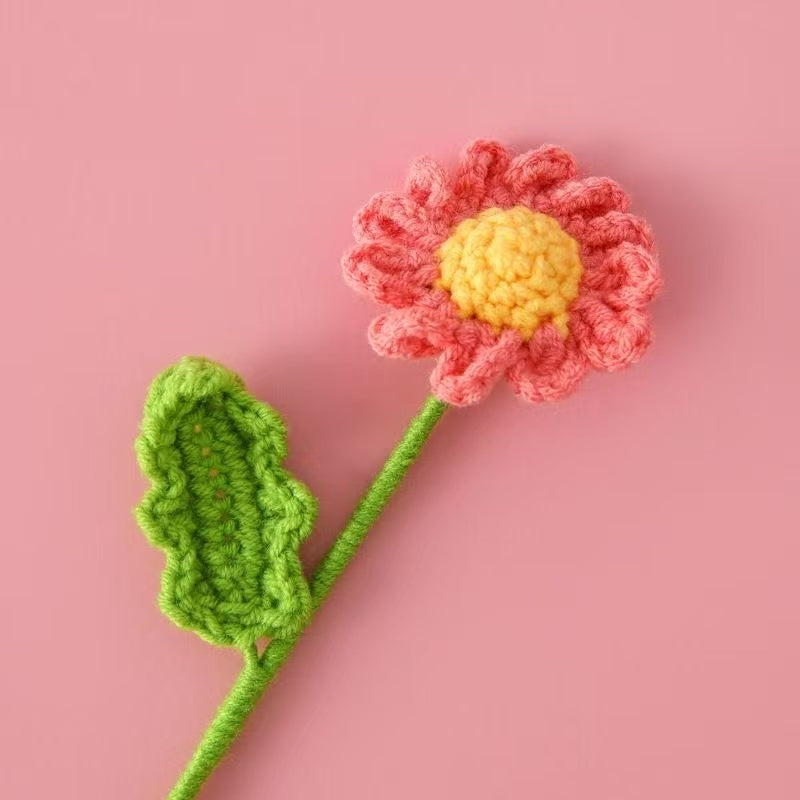 Pink crochet daisy flower with yellow centre and green stem – handmade floral gift for home décor, weddings, or sustainable gifting in the UK